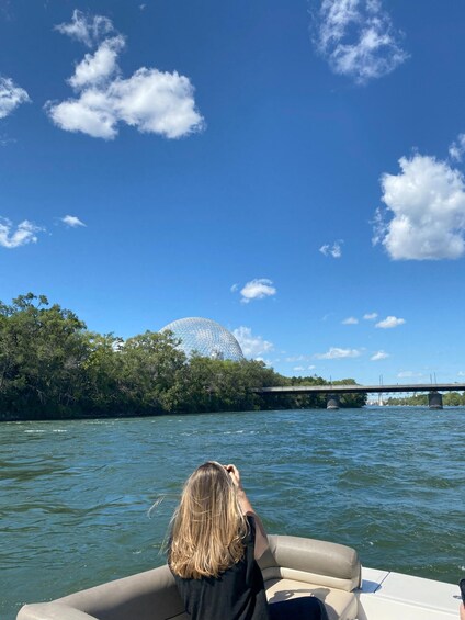 A person on a boat, a bridge, and a dome-like structure in the background. 2