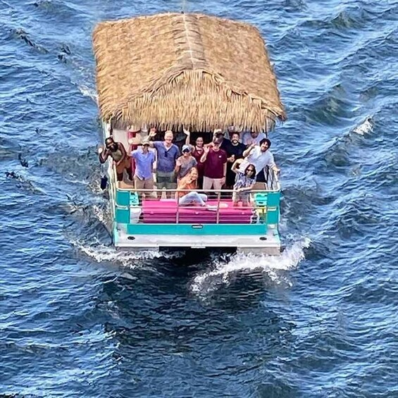 A boat with a thatched roof carrying passengers over choppy water. 2
