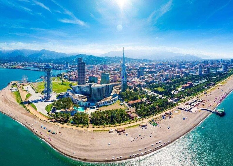 A coastal cityscape with a prominent tower, a beach, and a body of water. 5