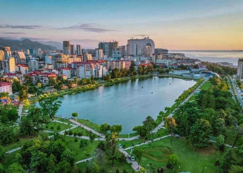 A cityscape with a large lake, modern buildings, and a park area. 1