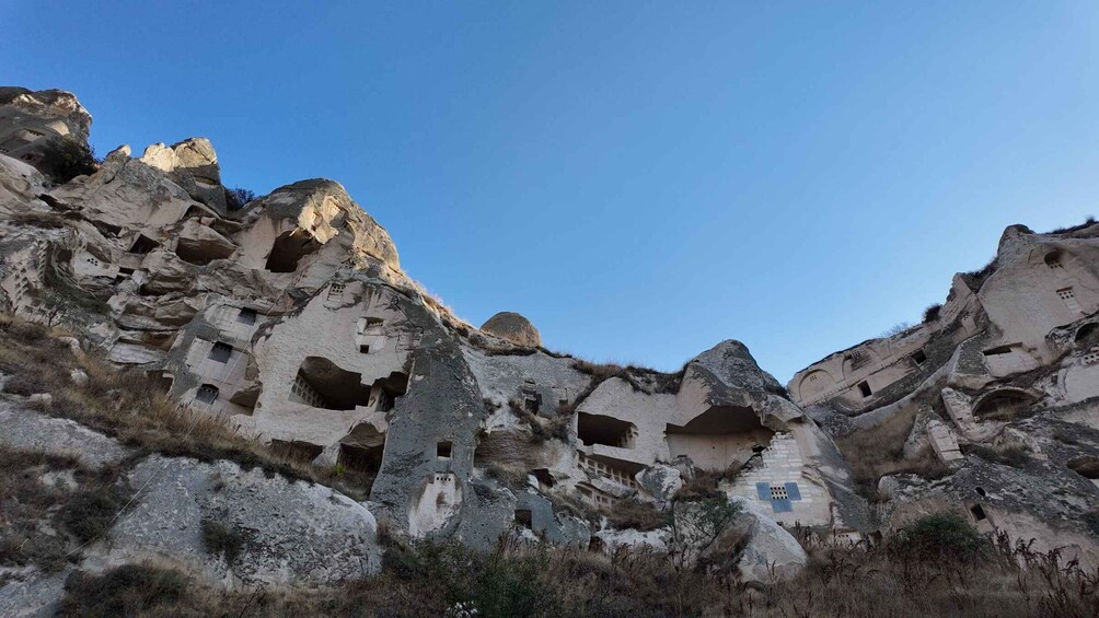 A rocky landscape with numerous cave dwellings carved into the cliffs. 3