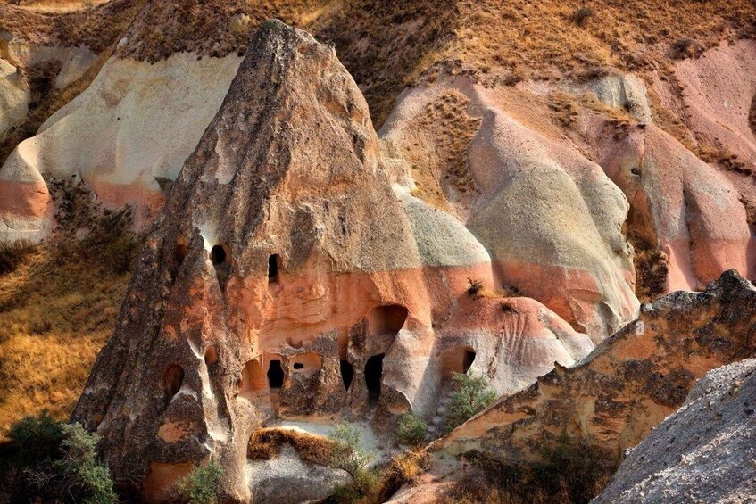 A rock formation with multiple caves and a rugged landscape. 2