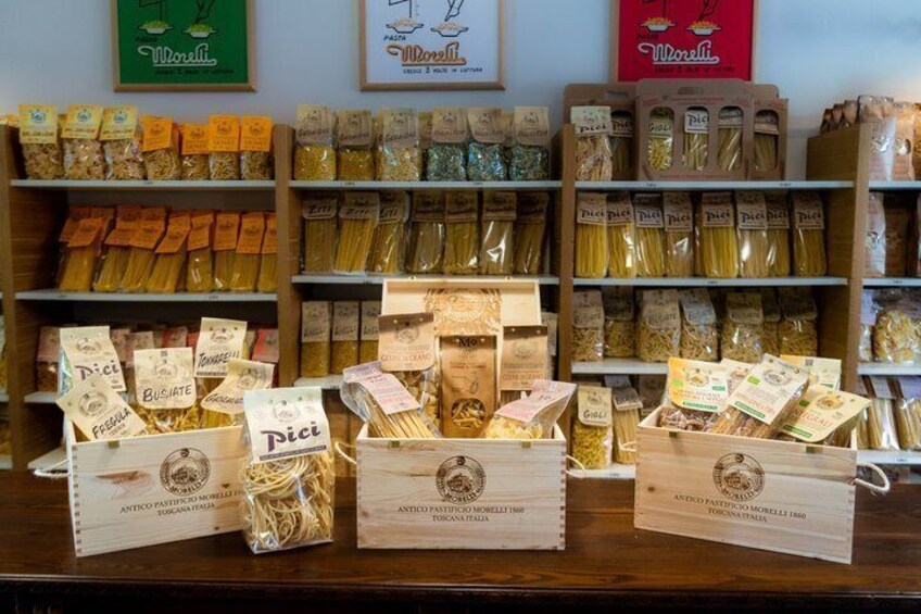 A variety of pasta brands displayed on shelves and in boxes. 4