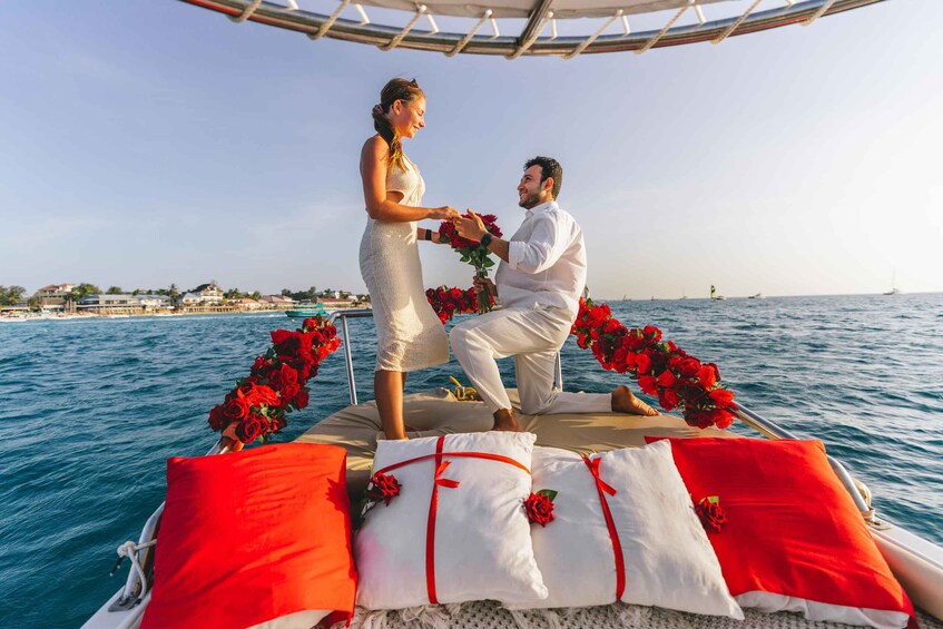 A couple on a boat with red roses, a clear sky, and a calm sea. 3