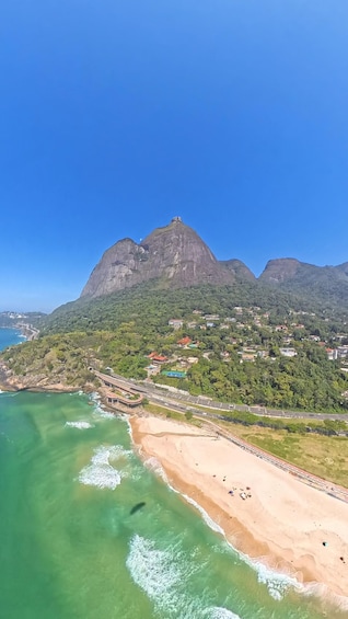 A coastal town with a prominent mountain, clear blue sky, and turquoise waters. 5