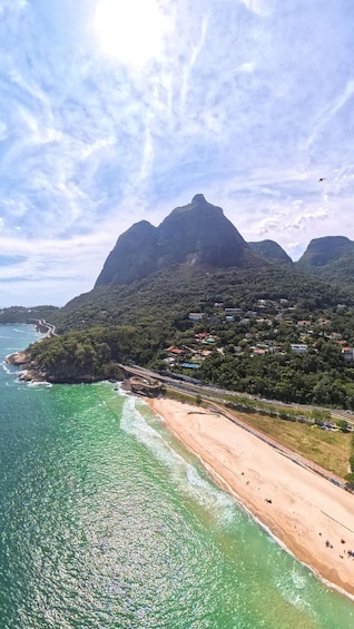 A coastal landscape with a beach, a road, and a mountain range. 2
