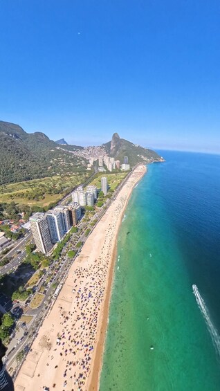 A coastal cityscape with a beach, high-rise buildings, and a prominent mountain. 4