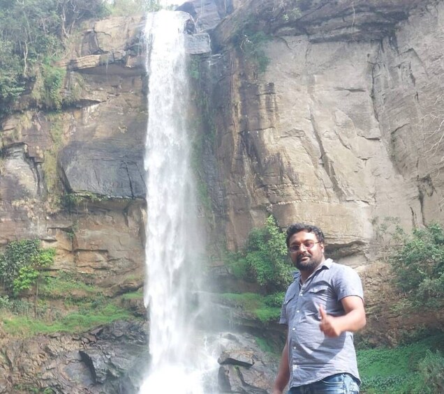 A waterfall cascading down a rocky cliff with greenery at the base. 2