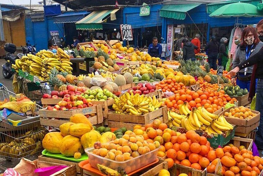 A bustling outdoor market with various fruits and vegetables displayed in crates and baskets. 1