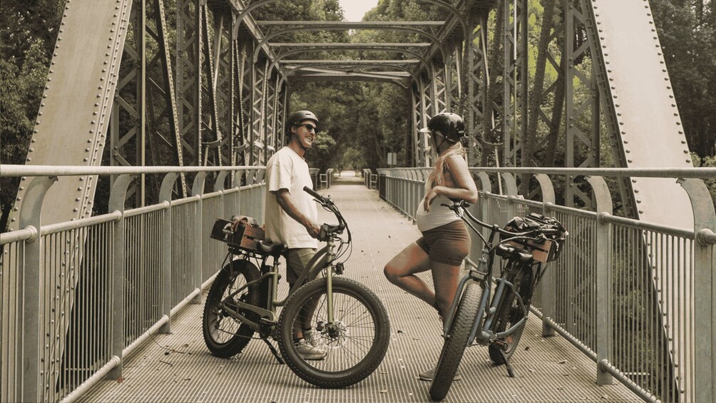 A man and a woman on a bridge with bicycles. 3