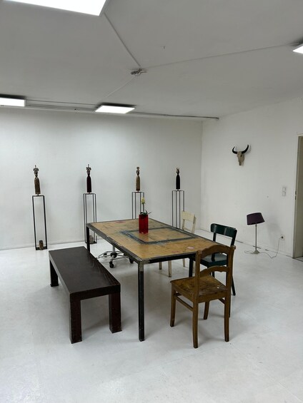 A room with a wooden table, benches, and decorative vases. 4