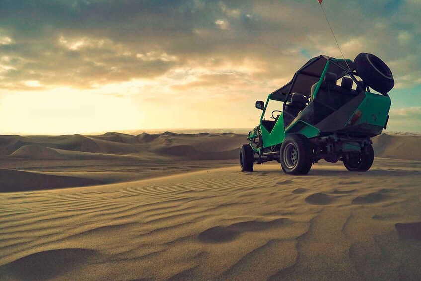 A green off-road vehicle with a roof rack in a desert landscape. 4
