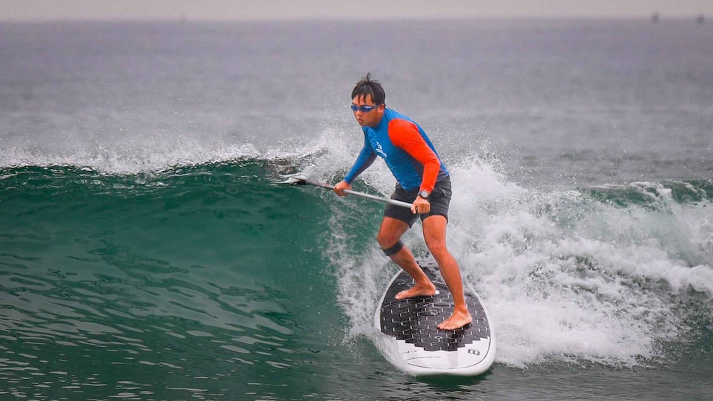 A person on a paddleboard in the ocean. 1