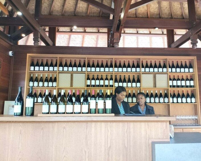 A wine cellar with wooden shelves stocked with wine bottles. 1