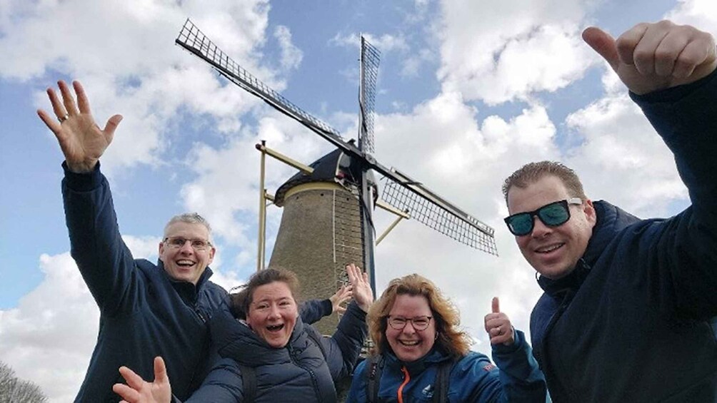A group of people with a windmill in the background. 1