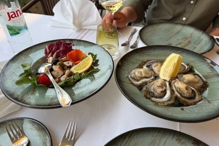 A table with plates of food, a bottle, and cutlery. 3
