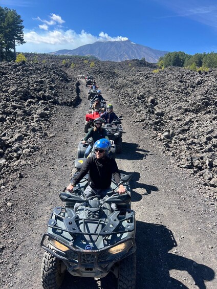 A group of people on ATVs on a rocky path with a mountain in the background. 4