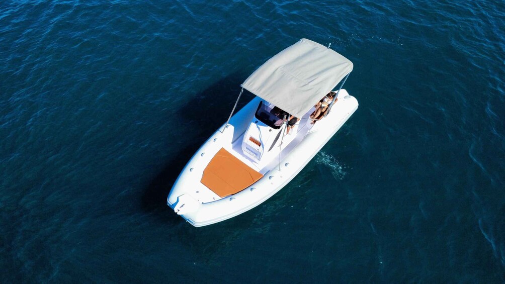 A white motorboat with a canopy on the water. 5