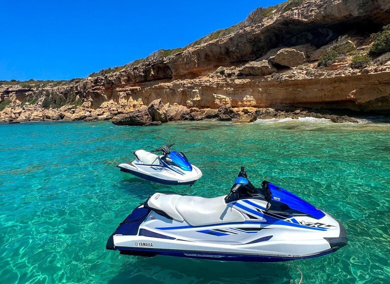 Two Yamaha jet skis on clear turquoise water with rocky cliffs in the background. 2
