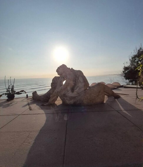 A rock formation on a coastal promenade with the ocean in the background. 4