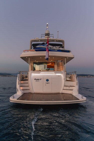A multi-deck yacht named 'Happy 3 Split' with a wake behind it, indicating movement through water. 2