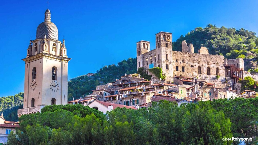 A historic town with a prominent clock tower and a large dome, surrounded by lush greenery and ancient stone buildings. 3