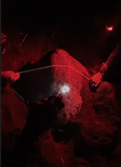 A red-lit environment with a white object on a textured surface. 4
