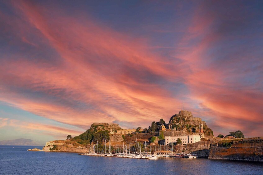 A coastal town with a prominent castle on a hill, surrounded by water and boats. 5
