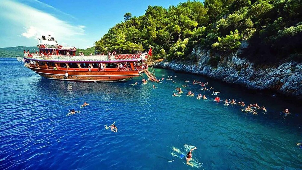 A boat with people swimming and snorkeling in the water. 3