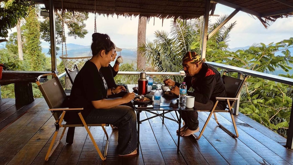 Two people dining at a wooden table with a view of a mountainous landscape. 2