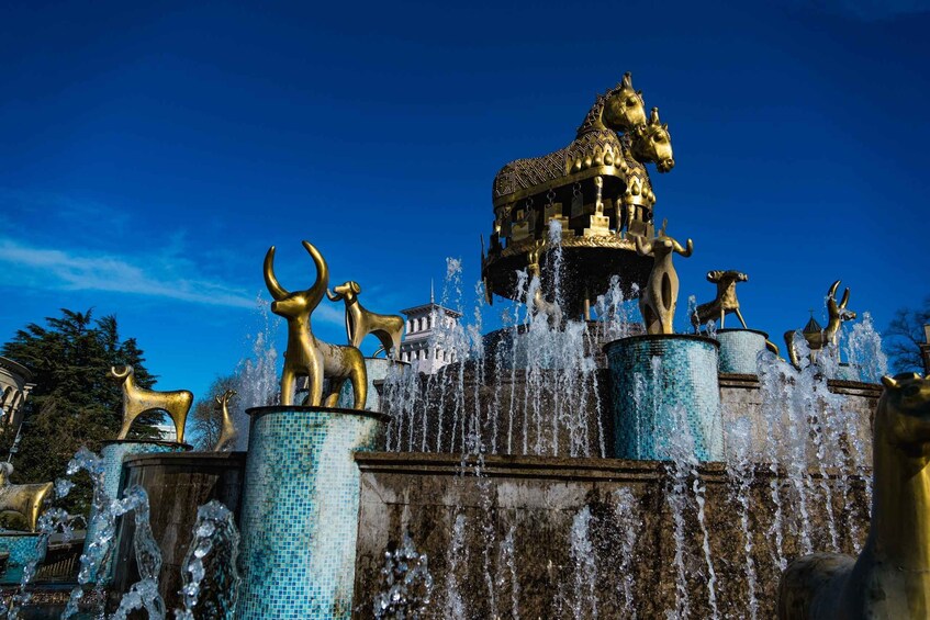 A fountain with golden statues and water jets. 1