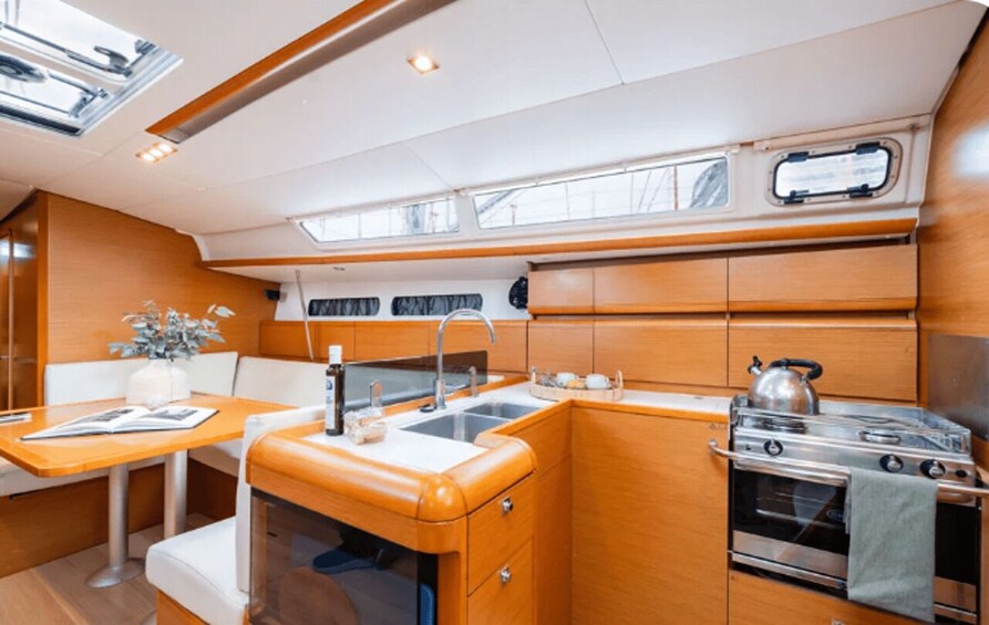 A compact galley with a stove, sink, and wooden cabinetry. 2