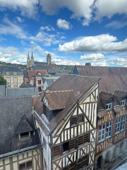 A town with medieval architecture, including half-timbered houses and a prominent church with a tall spire. 4