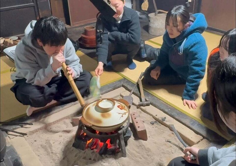 People around a traditional stove cooking food. 1