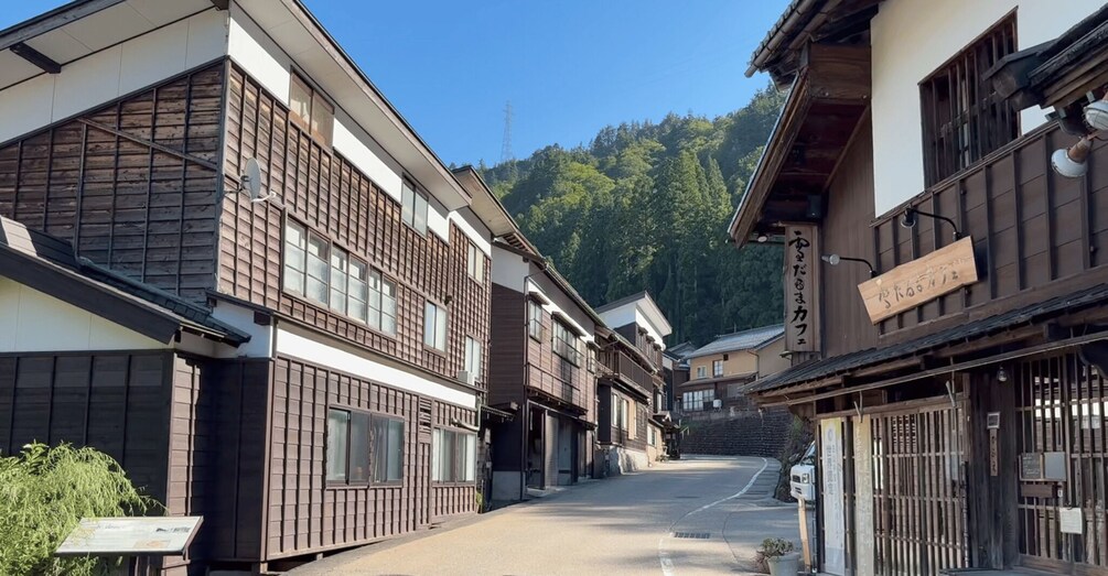 A traditional Japanese street with wooden buildings and a mountain in the background. 3