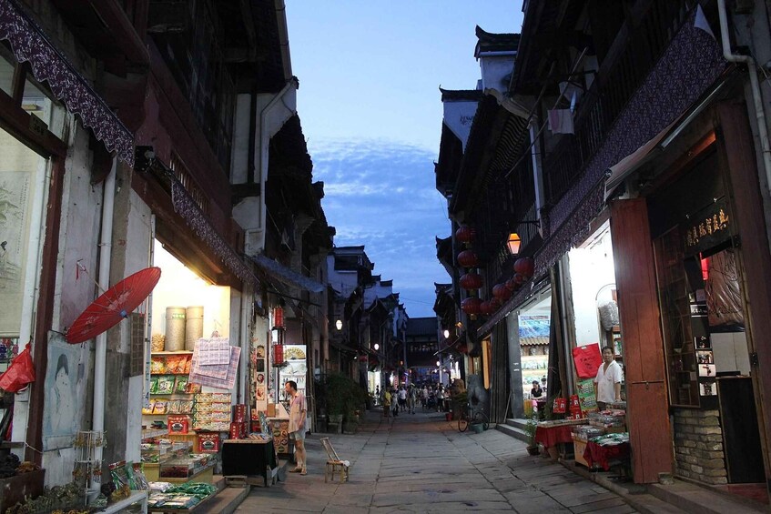A narrow street lined with traditional buildings, some with shops on the ground floor. 5