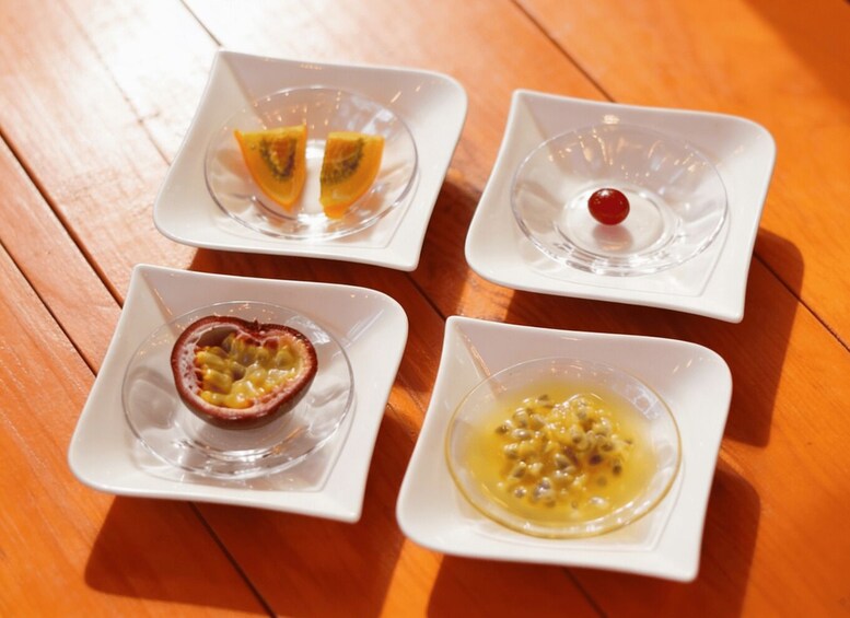 Four square white dishes with different food items on a wooden table. 5