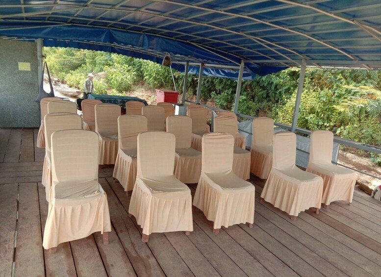 A covered outdoor seating area with rows of chairs and a person in the background. 4