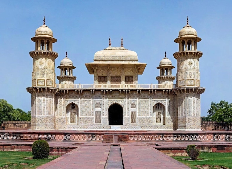 A large, ornate building with domes and minarets, surrounded by a well-maintained garden. 4