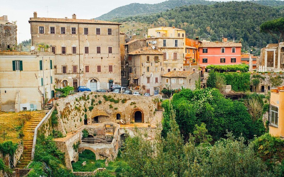 A historic town with ancient ruins, colorful buildings, and lush greenery. 1