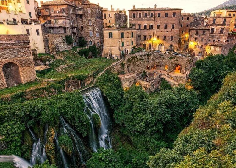 A historic town with a cascading waterfall surrounded by lush greenery and traditional architecture. 2