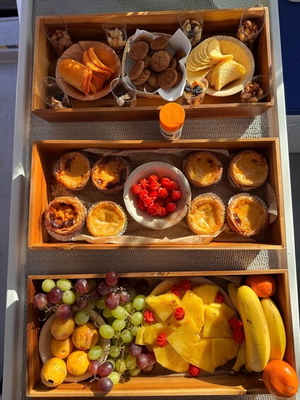 A wooden tray with pastries, nuts, and a glass of orange juice. 2