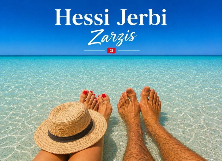 A beach with clear turquoise water and a person's legs and feet in the sand. 1