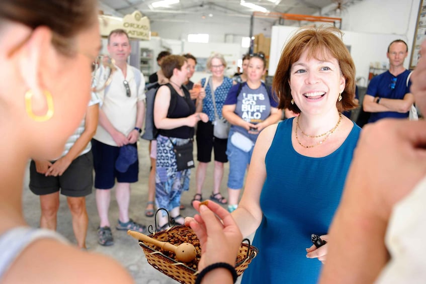 A group of people in an indoor setting, some holding food items. 4