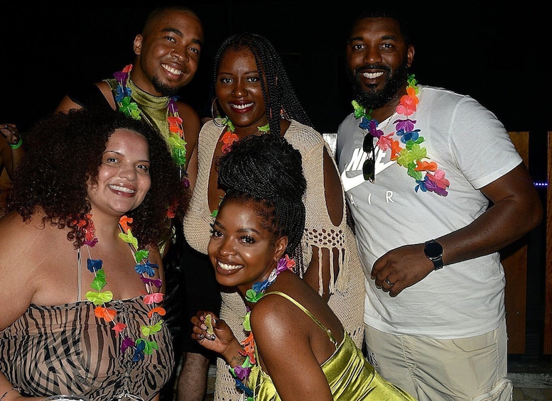 A group of people at a social event, wearing casual and festive attire with leis. 4