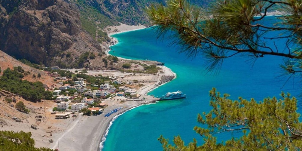 A coastal town with a clear blue sea, a beach, and a cruise ship. 3