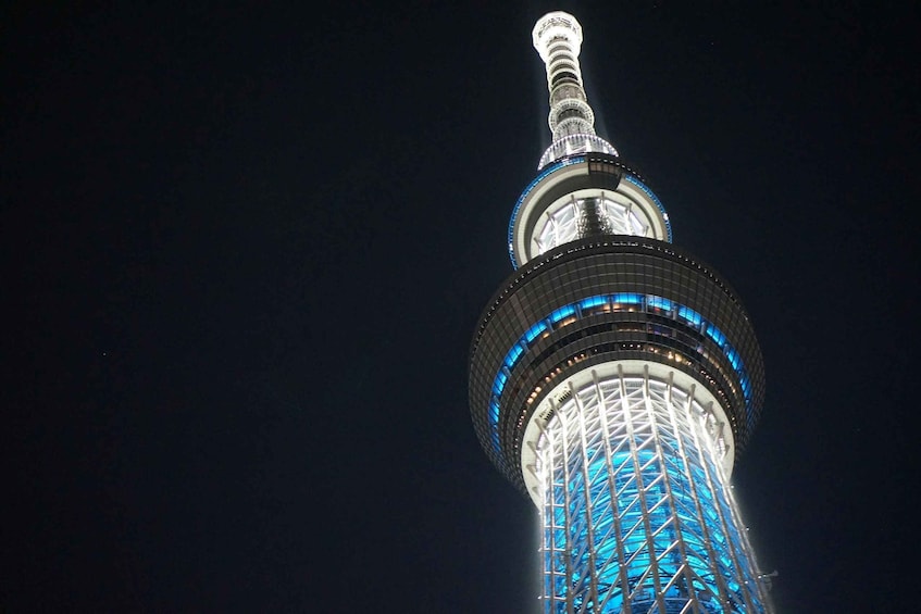 A tall tower with a spire, illuminated blue lights, and a grid-like structure. 5