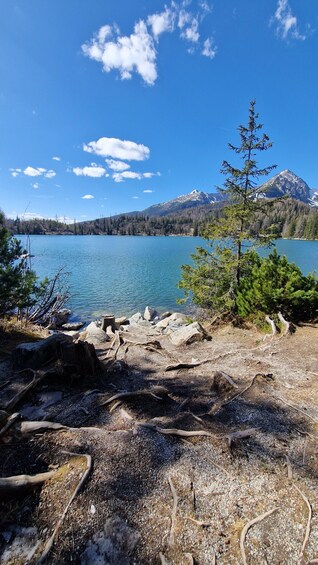 A lake with mountains in the background, surrounded by trees and rocks. 3
