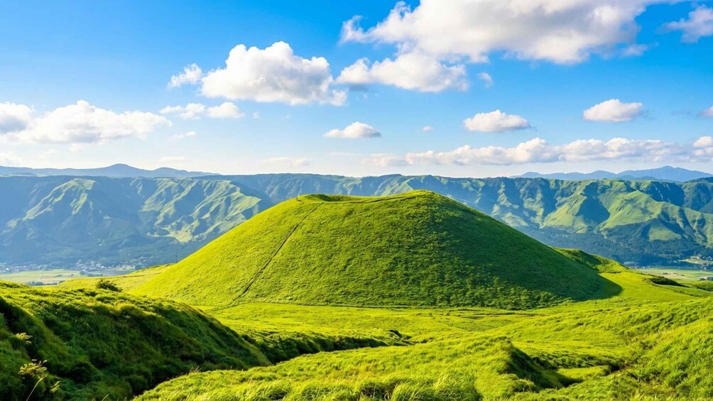 A green hill with a clear sky and distant mountains. 3