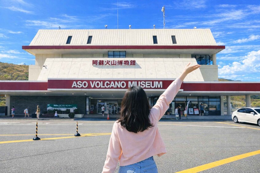 The entrance to the ASO Volcano Museum with a person raising their hand. 4